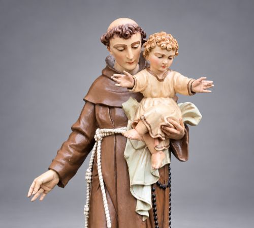 fig 5. An antique polychrome carved wood sculpture depicting Saint Anthony in a brown Franciscan habit holding the Christ Child.