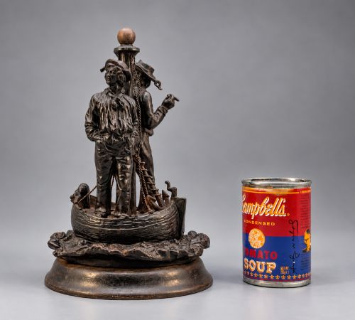fig 1. A nineteenth-century dark patinated bronze sculpture depicting two fishermen standing in a small vessel atop sculpted ocean waves, mounted on a rounded base.