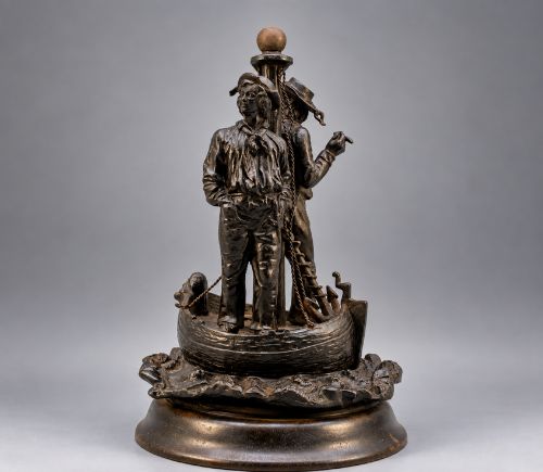 fig 2. A nineteenth-century dark patinated bronze sculpture depicting two fishermen standing in a small vessel atop sculpted ocean waves, mounted on a rounded base.