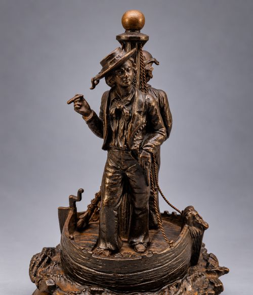 fig 8. A nineteenth-century dark patinated bronze sculpture depicting two fishermen standing in a small vessel atop sculpted ocean waves, mounted on a rounded base.