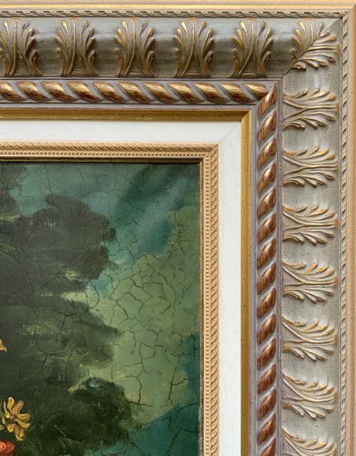 fig 9. A classical oil painting displaying a bowl of fruit, a urn with flowers, asparagus, and melons set against a dark landscape backdrop within a carved silver-grey frame.
