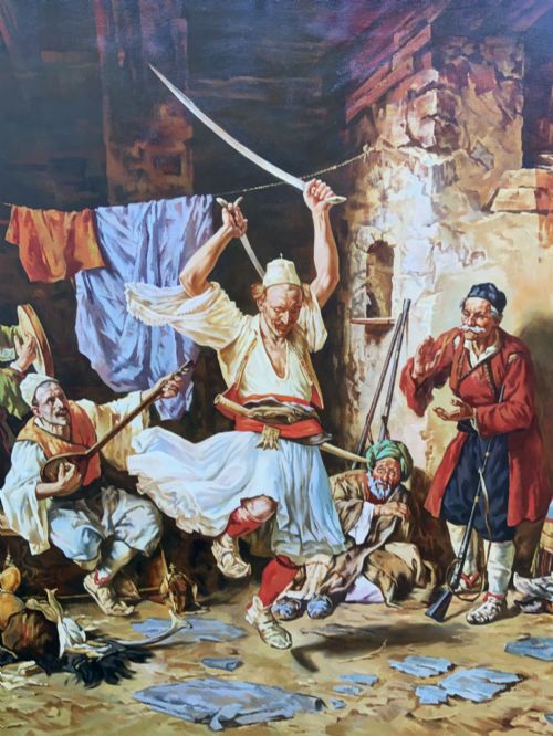 fig 7. A large mid-century framed oil painting depicting figures in traditional attire watching a man perform a sword dance inside a rustic interior.