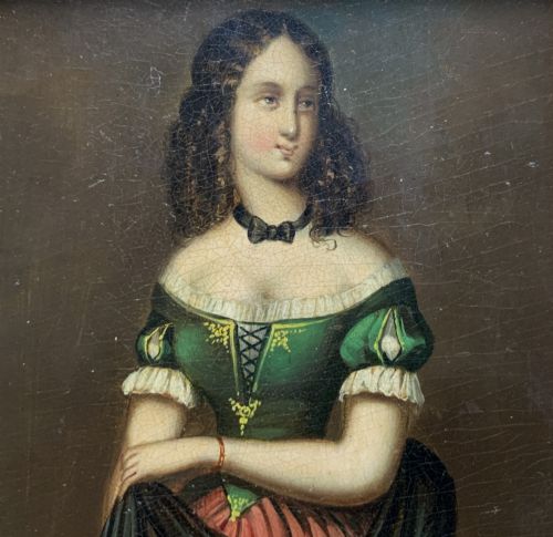 fig 2. A framed miniature oil portrait depicting a Victorian woman with dark curly hair in a green and red dress, enclosed in a gilded wooden frame with egg-and-dart detail.