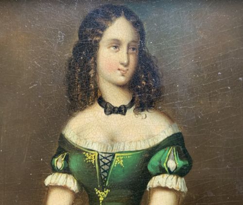 fig 4. A framed miniature oil portrait depicting a Victorian woman with dark curly hair in a green and red dress, enclosed in a gilded wooden frame with egg-and-dart detail.