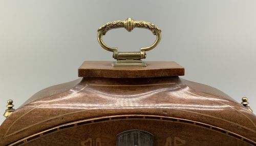 fig 5. An Edwardian mahogany desk compendium featuring an inlaid floral swag motif, central thermometer, clock dial, barometer dial, and top brass handle.