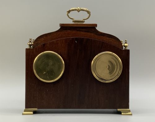 fig 9. An Edwardian mahogany desk compendium featuring an inlaid floral swag motif, central thermometer, clock dial, barometer dial, and top brass handle.