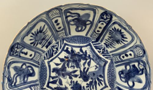 fig 2. A circular 16th-century Chinese Kraak porcelain charger decorated in cobalt blue underglaze featuring a central floral scene surrounded by a panelled foliate rim.