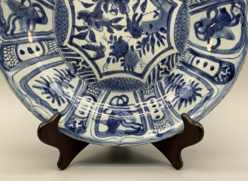 fig 3. A circular 16th-century Chinese Kraak porcelain charger decorated in cobalt blue underglaze featuring a central floral scene surrounded by a panelled foliate rim.