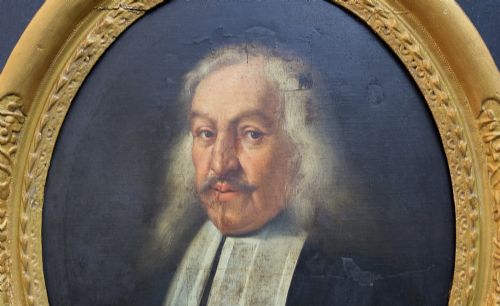 fig 2. An oval 17th-century oil painting depicting a gentleman with grey hair, a moustache, and white falling bands collar in a carved gold frame.