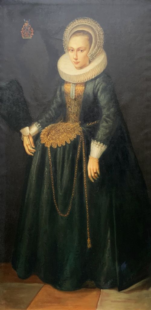 fig 1. A full-length oil painting depicting a noblewoman dressed in a dark green gown, large white lace ruff collar, and bonnet, set within a dark frame.