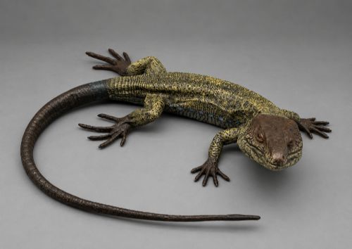 fig 7. An antique cold-painted bronze sculpture depicting a realistic lizard with textured yellow and brown skin, blue accents, and a long curved tail.