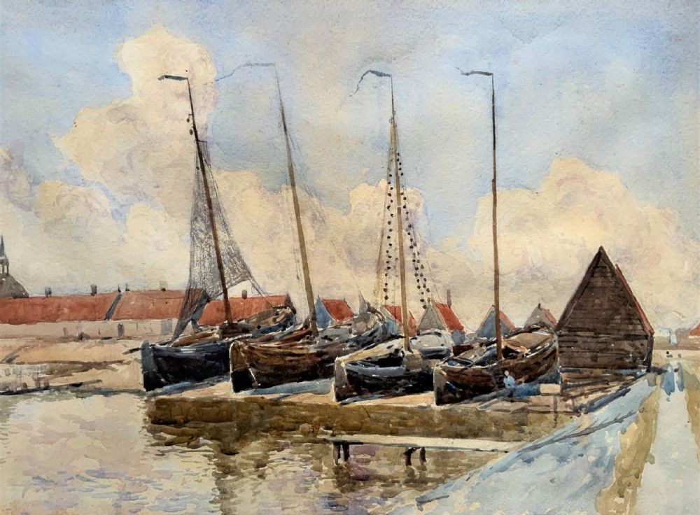 A 19th-century watercolour painting depicting several wooden sailing boats docked at a boat yard alongside buildings, housed within a wide gilt mount and thin gilt frame. View III