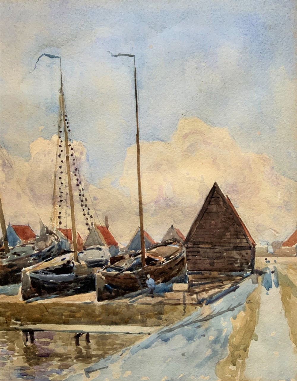 A 19th-century watercolour painting depicting several wooden sailing boats docked at a boat yard alongside buildings, housed within a wide gilt mount and thin gilt frame. View IV