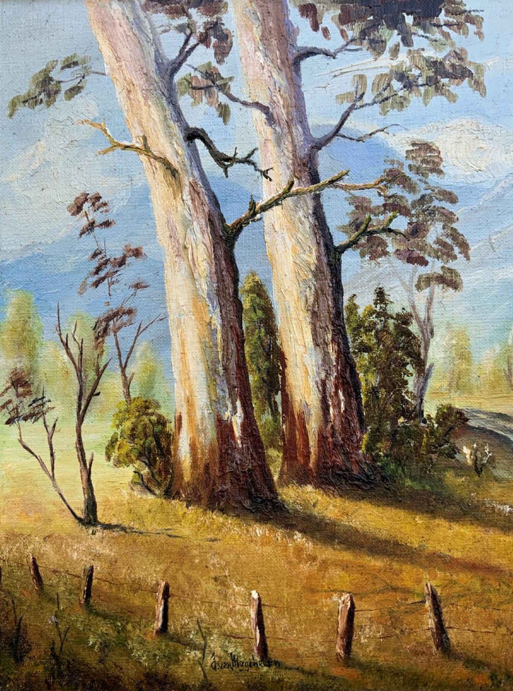 A mid-century oil landscape painting depicting tall gum trees beside a lake against blue mountains, framed in a gilt and fabric-lined wooden frame. View IV