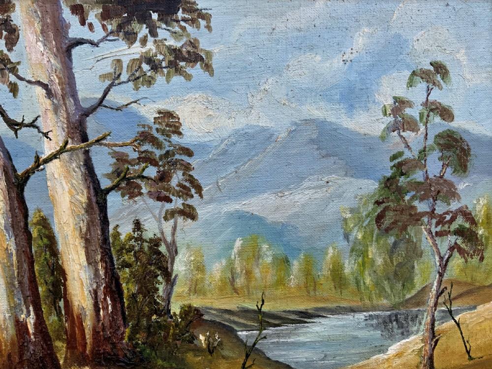 A mid-century oil landscape painting depicting tall gum trees beside a lake against blue mountains, framed in a gilt and fabric-lined wooden frame. View VI