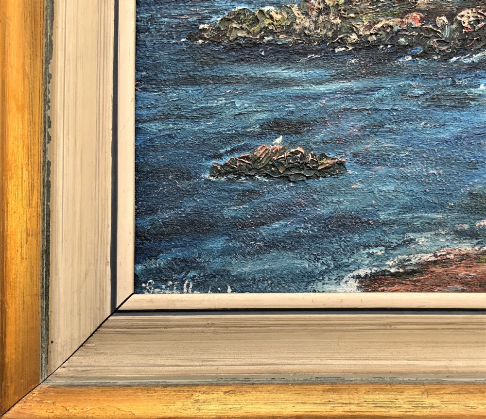 An impressionist framed oil painting depicting a Welsh coastal scene with a cottage on a rocky island under a blue and pink sky. View X
