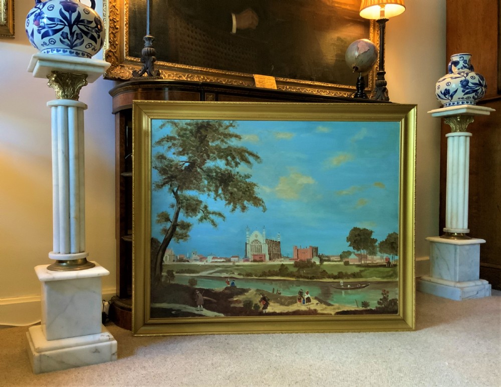 A large framed oil painting depicting Eton College Chapel across the River Thames with figures along the foreground bank under a blue sky. View VIII
