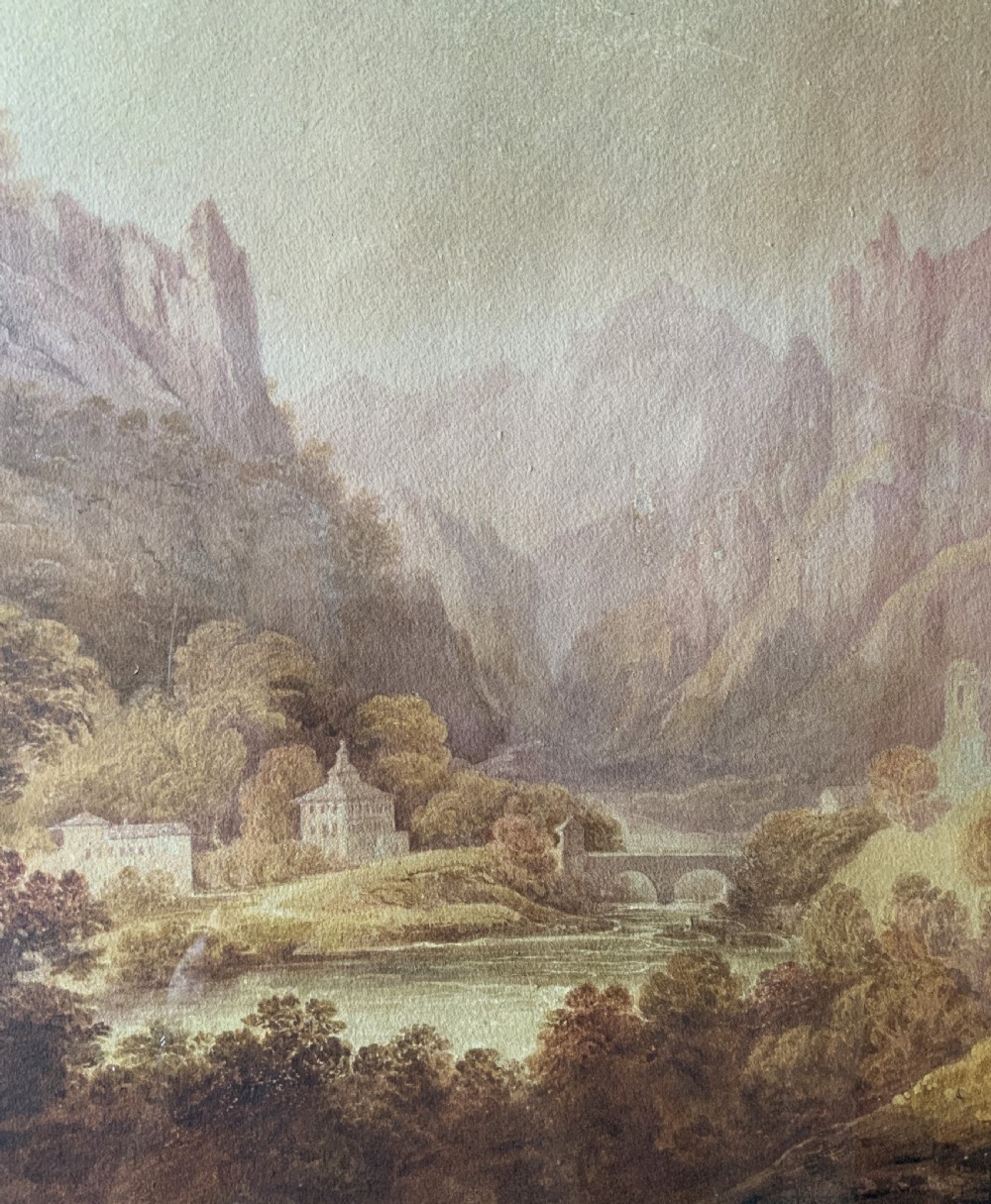 An antique 19th-century watercolour painting depicting a mountainous river landscape set within an arched cream mount and gilt wooden frame. View VI