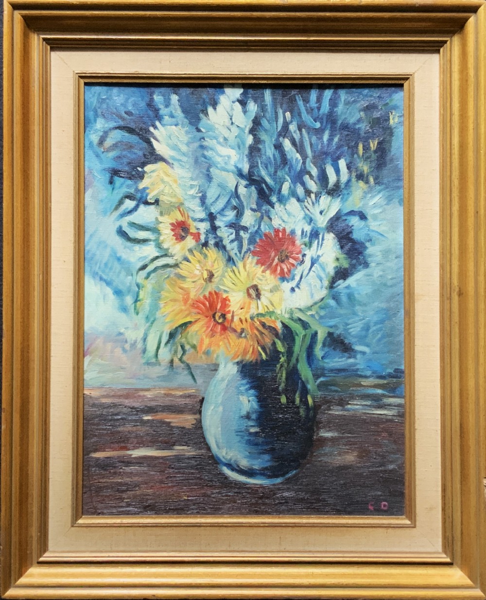 An impressionist oil painting depicting yellow and orange flowers in a blue vase against a textured blue backdrop, framed in a moulded gilt wooden frame.
