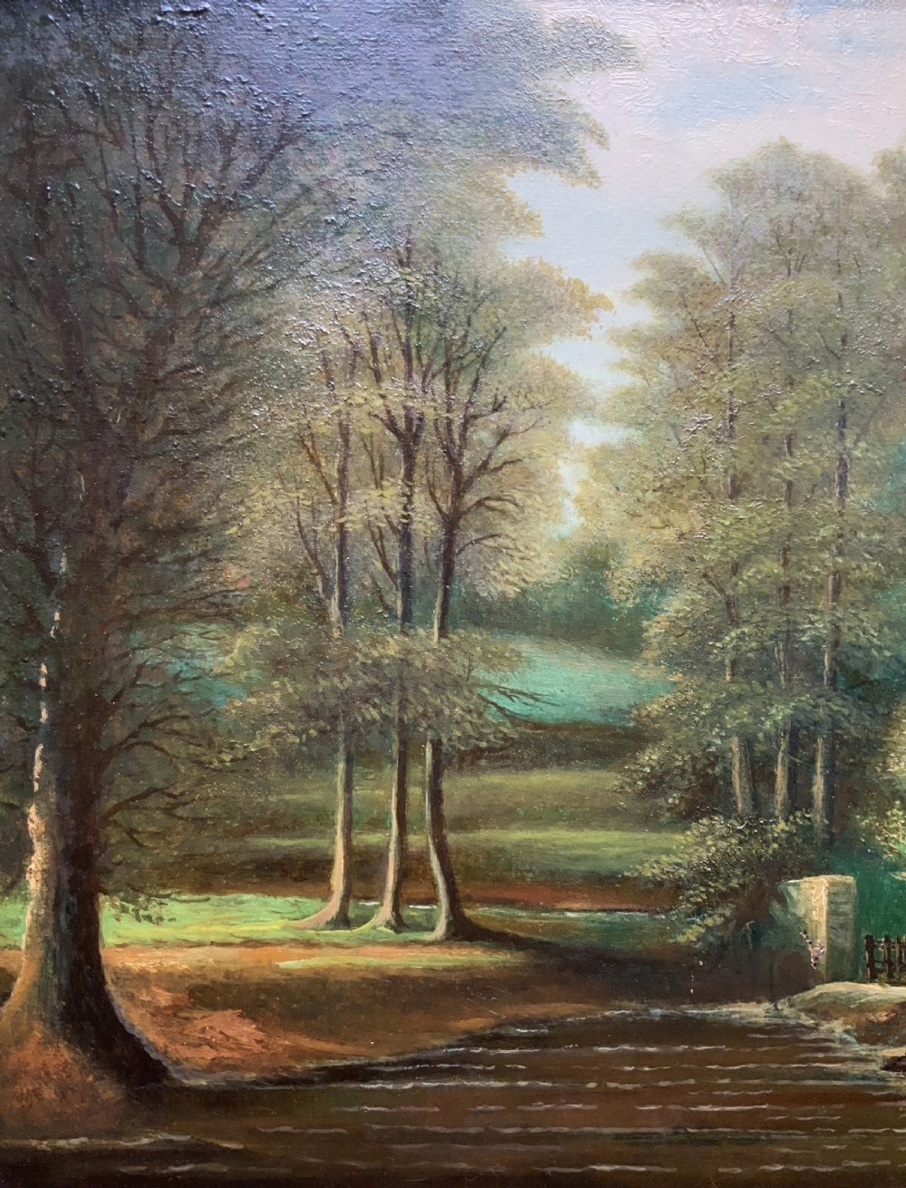 An early 20th-century landscape oil painting displaying a woodland river scene with a figure fishing near a weir, encased in a deep gold frame. View VIII
