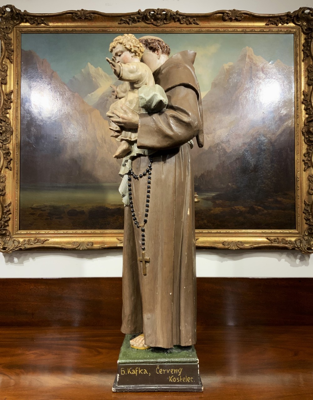 A carved polychrome wood statue depicting a saint in a brown robe holding the infant Jesus. View VII