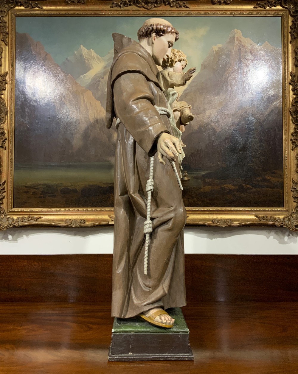 A carved polychrome wood statue depicting a saint in a brown robe holding the infant Jesus. View X