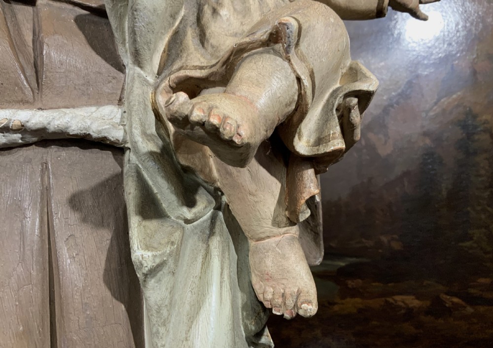 A carved polychrome wood statue depicting a saint in a brown robe holding the infant Jesus. View XVI