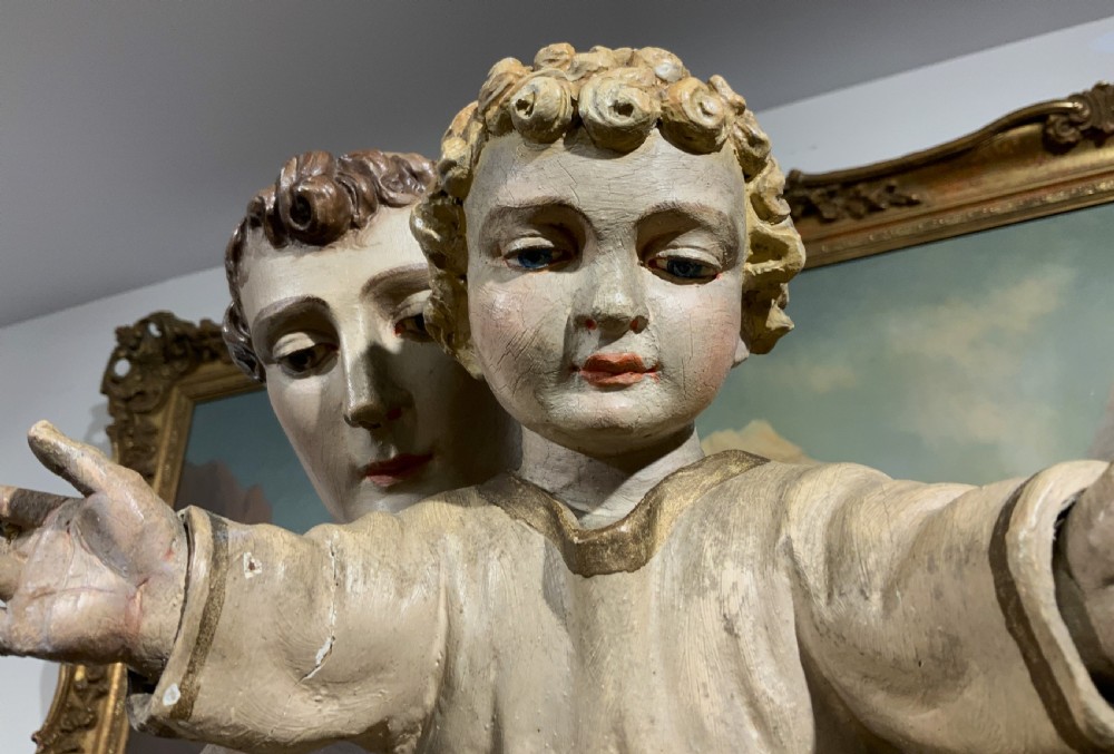 A carved polychrome wood statue depicting a saint in a brown robe holding the infant Jesus. View XVIII