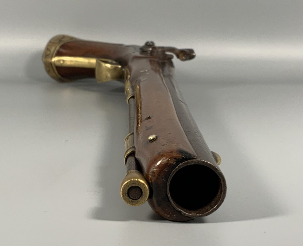 A 19th-century Regency smooth-bore percussion pistol with a carved walnut stock, engraved steel lockwork, and brass fittings. View VIII