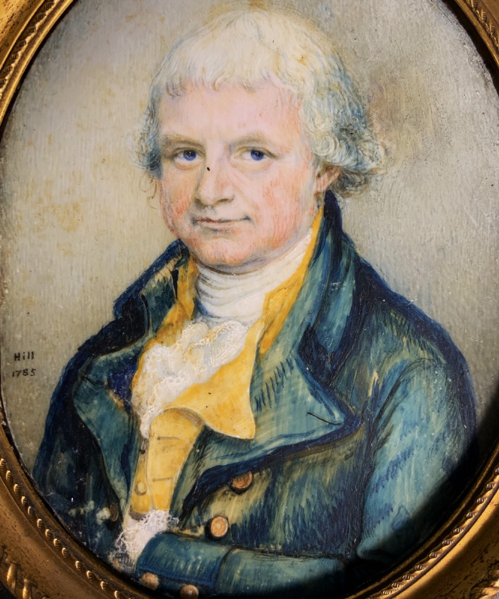 An oval Georgian portrait miniature of a gentleman with grey hair, wearing a blue coat and yellow waistcoat, set within a gilded rope-twist frame. View VIII