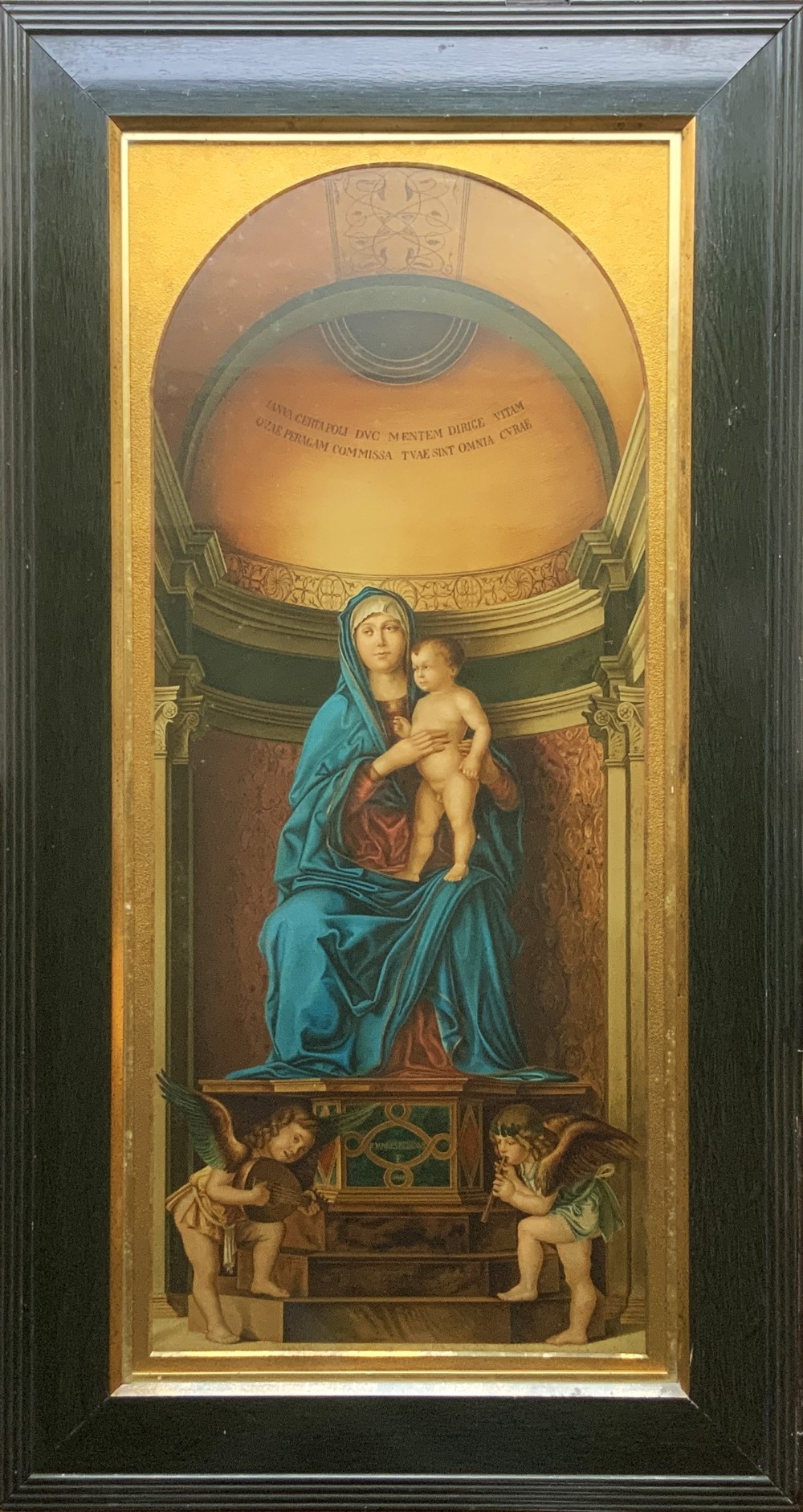 A framed antique religious art print depicting the Madonna and Child within a gilt arched alcove above two musical cherubs, set in a dark moulded frame.