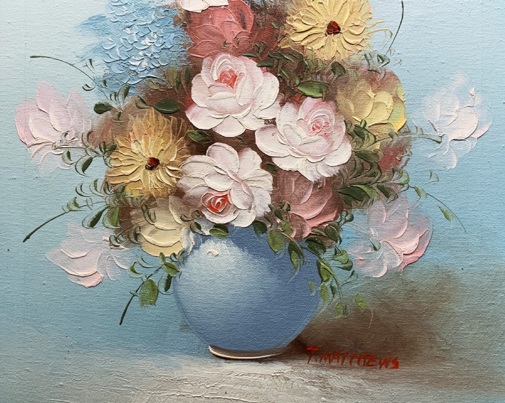 A framed post-war floral still life oil painting depicting pink, yellow, and blue flowers in a rounded blue vase within a gilt wooden frame. View VI