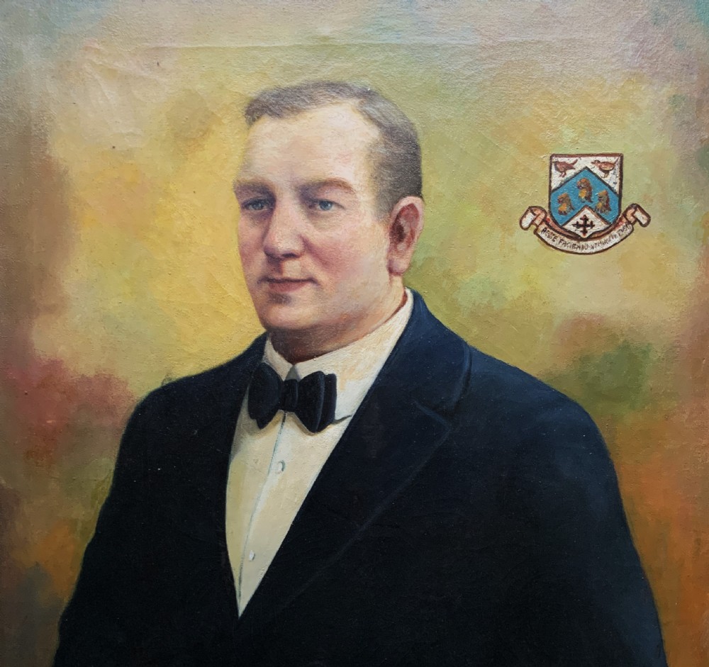 A framed oil portrait painting depicting a gentleman in a dark suit holding a paper document beside a small coat of arms. View III