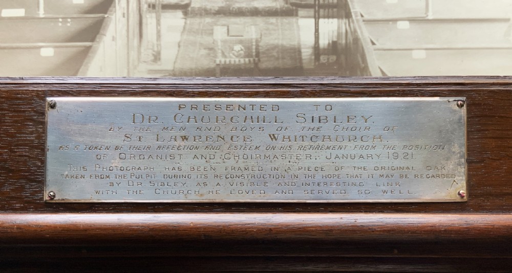 A 1921 sepia photograph depicting a church altar and choir, mounted in a moulded dark oak frame with an engraved metal presentation plaque along the bottom edge. View X