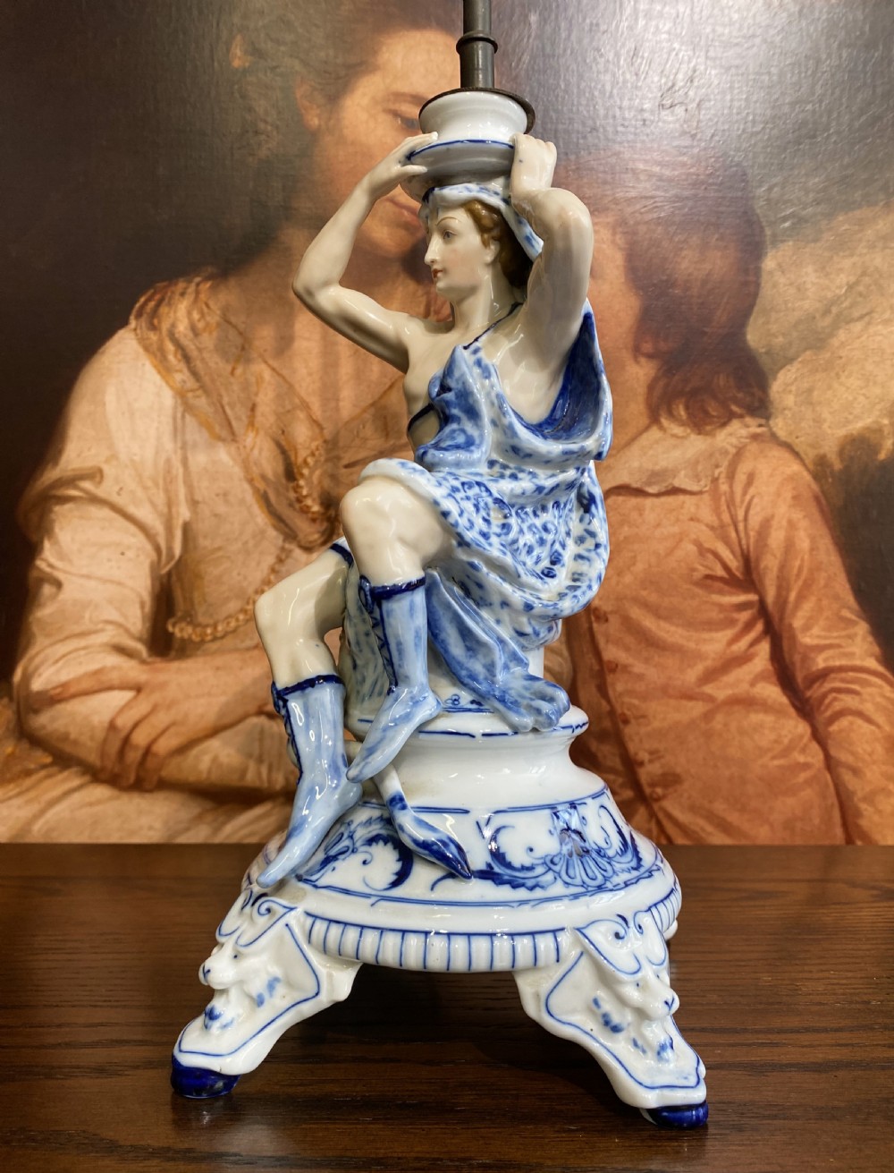 An Art Deco blue and white porcelain table lamp featuring a sculpted male figure on a decorative pedestal with a twin brass light socket stem. View XI