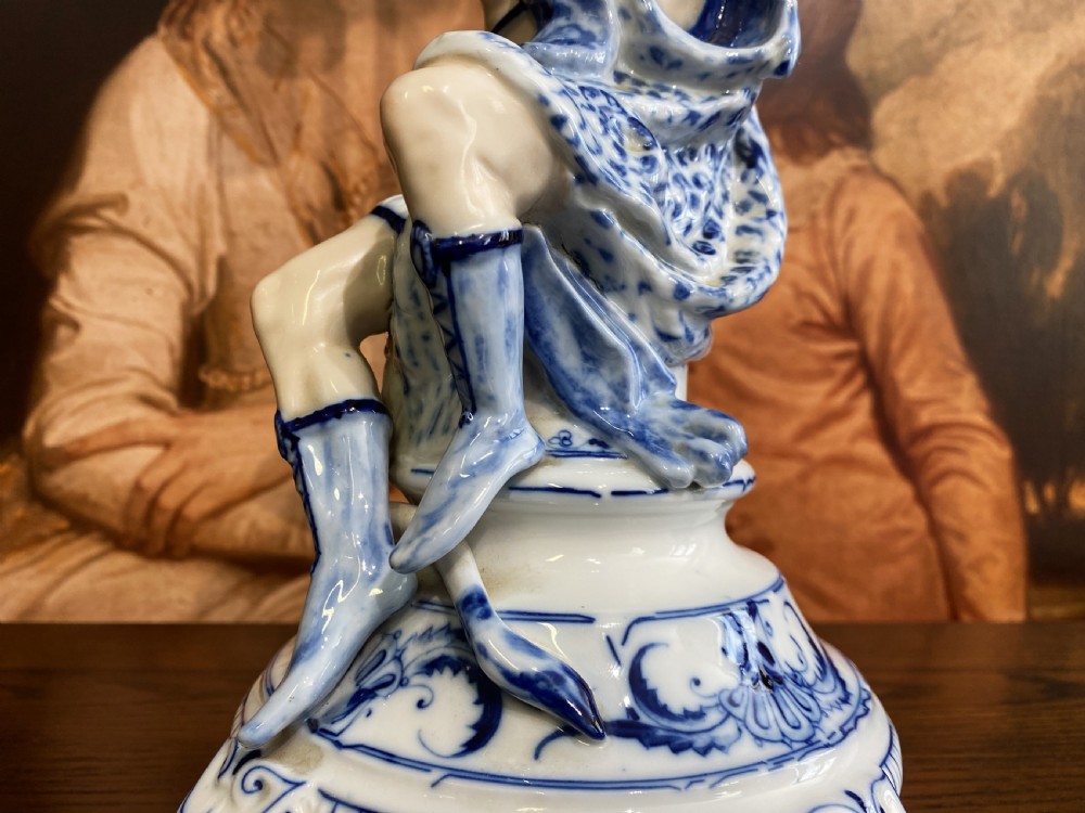 An Art Deco blue and white porcelain table lamp featuring a sculpted male figure on a decorative pedestal with a twin brass light socket stem. View XIII