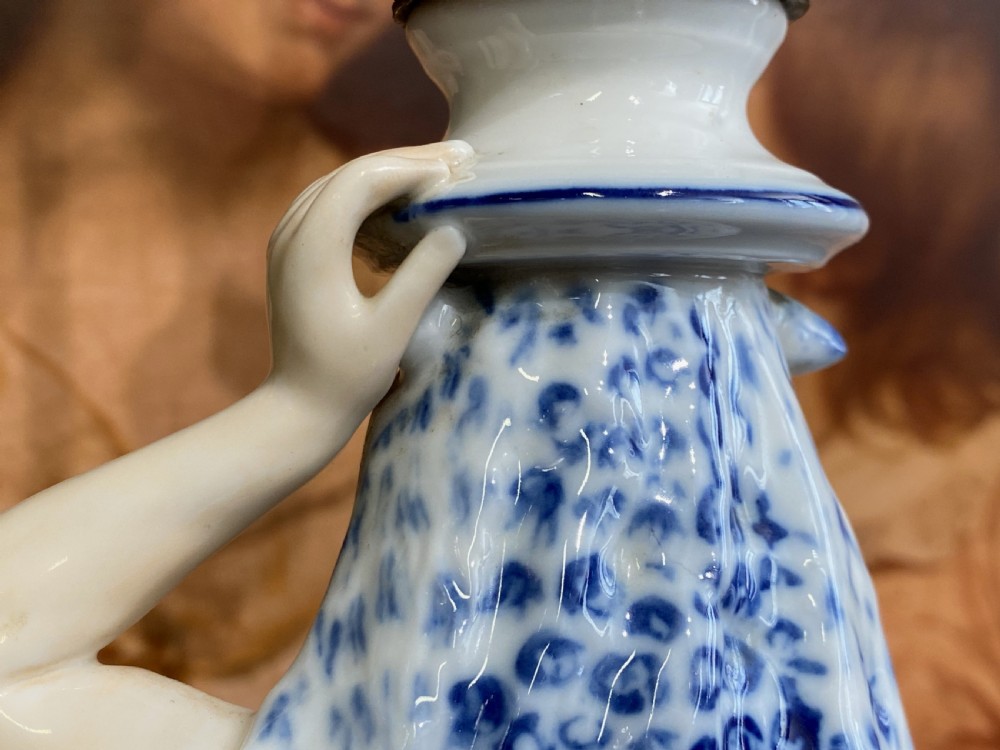 An Art Deco blue and white porcelain table lamp featuring a sculpted male figure on a decorative pedestal with a twin brass light socket stem. View XV