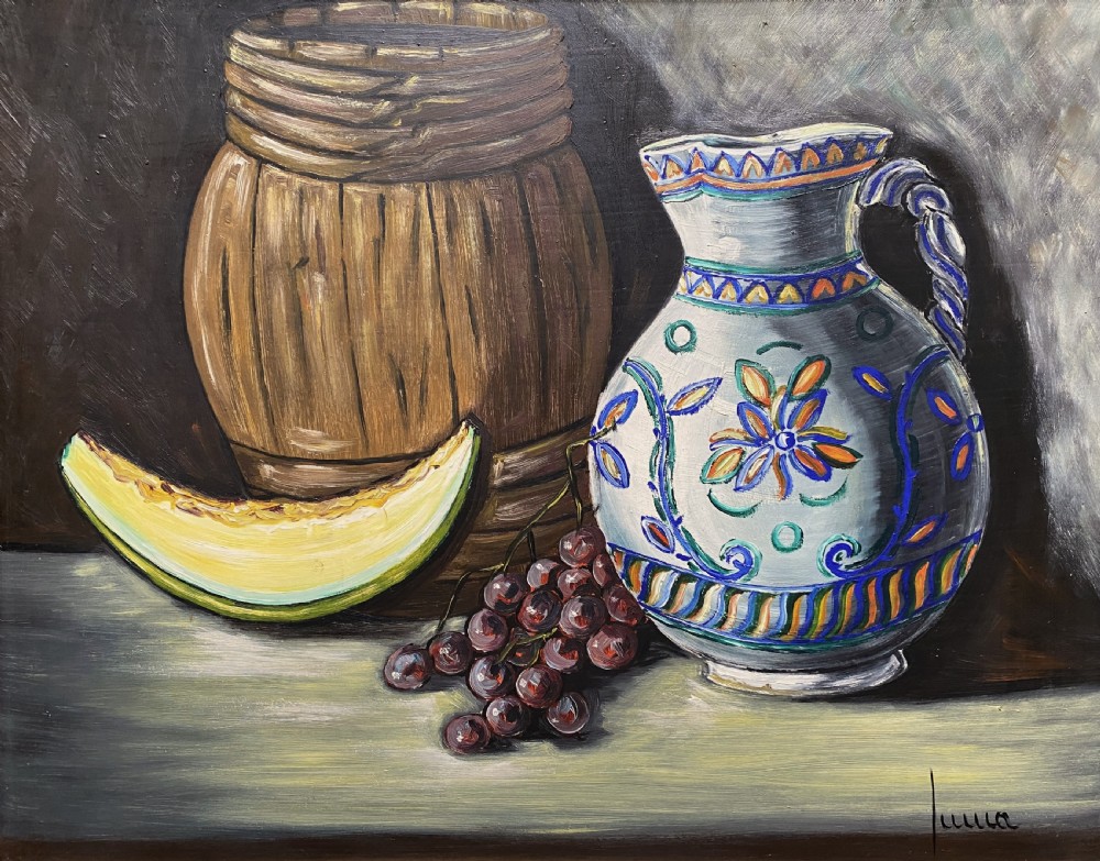 A framed mid-century oil painting depicting a still life composition with a blue patterned ceramic jug, a wooden barrel, a melon slice, and purple grapes. View II