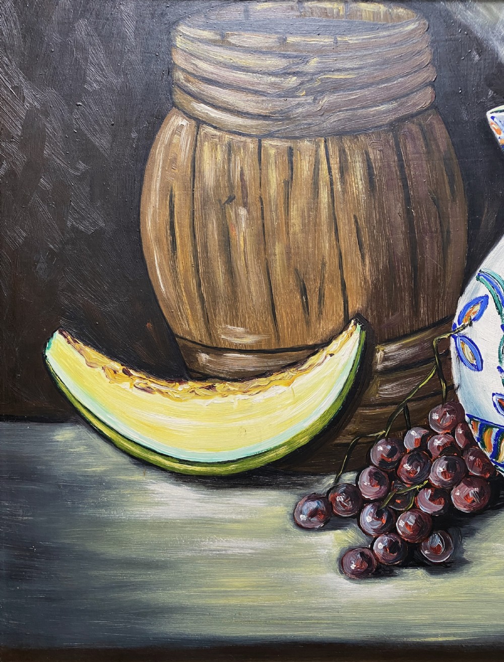 A framed mid-century oil painting depicting a still life composition with a blue patterned ceramic jug, a wooden barrel, a melon slice, and purple grapes. View V
