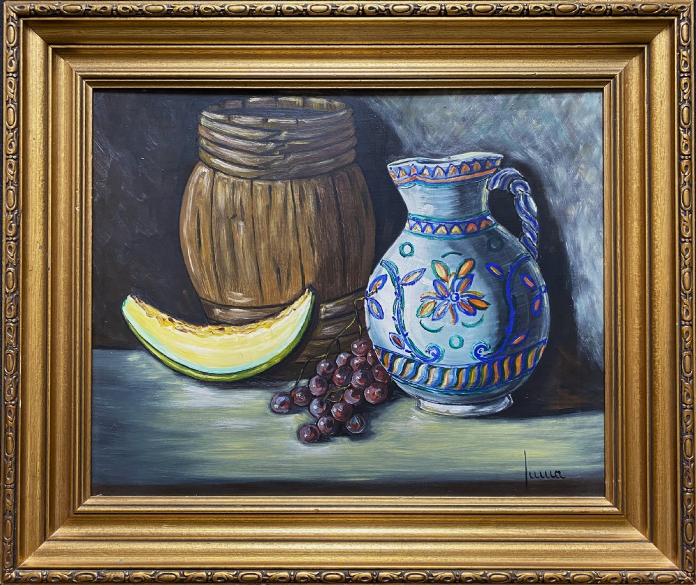 A framed mid-century oil painting depicting a still life composition with a blue patterned ceramic jug, a wooden barrel, a melon slice, and purple grapes. View X