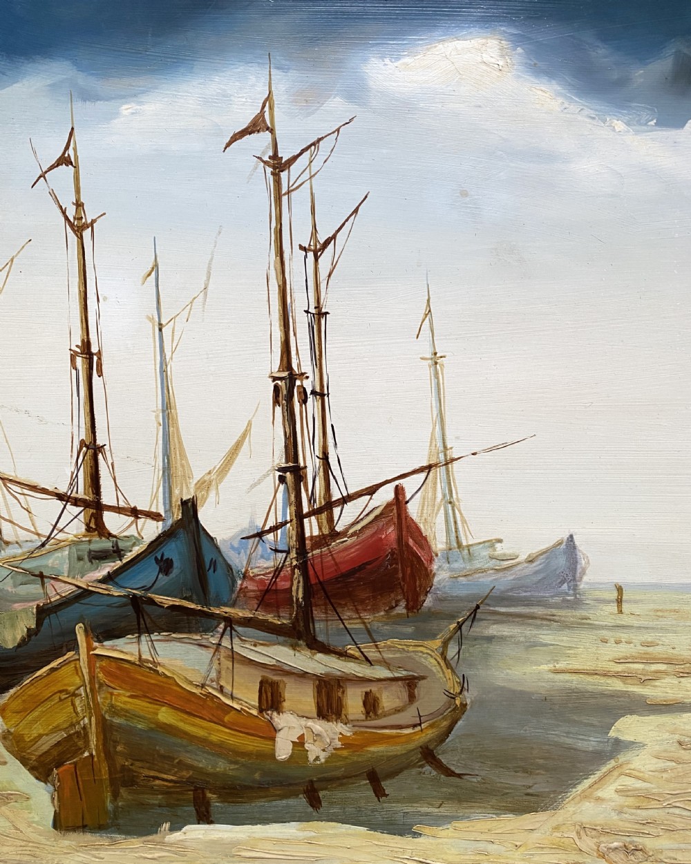 A horizontal mid-century oil painting depicting grounded fishing vessels on a sandy harbour floor beneath a cloudy blue sky, contained within a textured brown frame. View VII