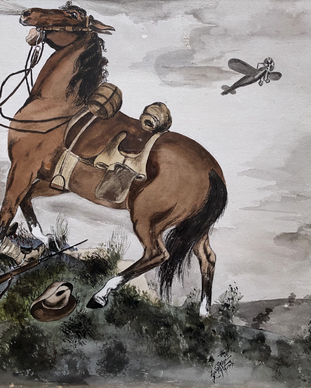 A framed 1917 watercolour painting depicting a fallen soldier beside a rearing horse on a battlefield under an aircraft-filled sky. View V