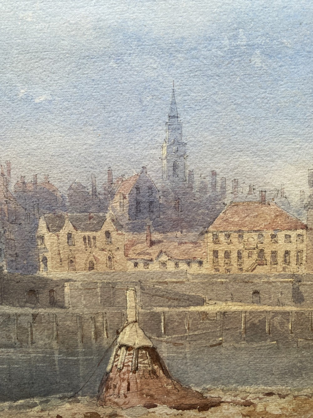 A framed 19th-century watercolour painting depicting a river and stone arch bridge in Hereford with a skyline, set within a gilded frame and cream mount. View IX