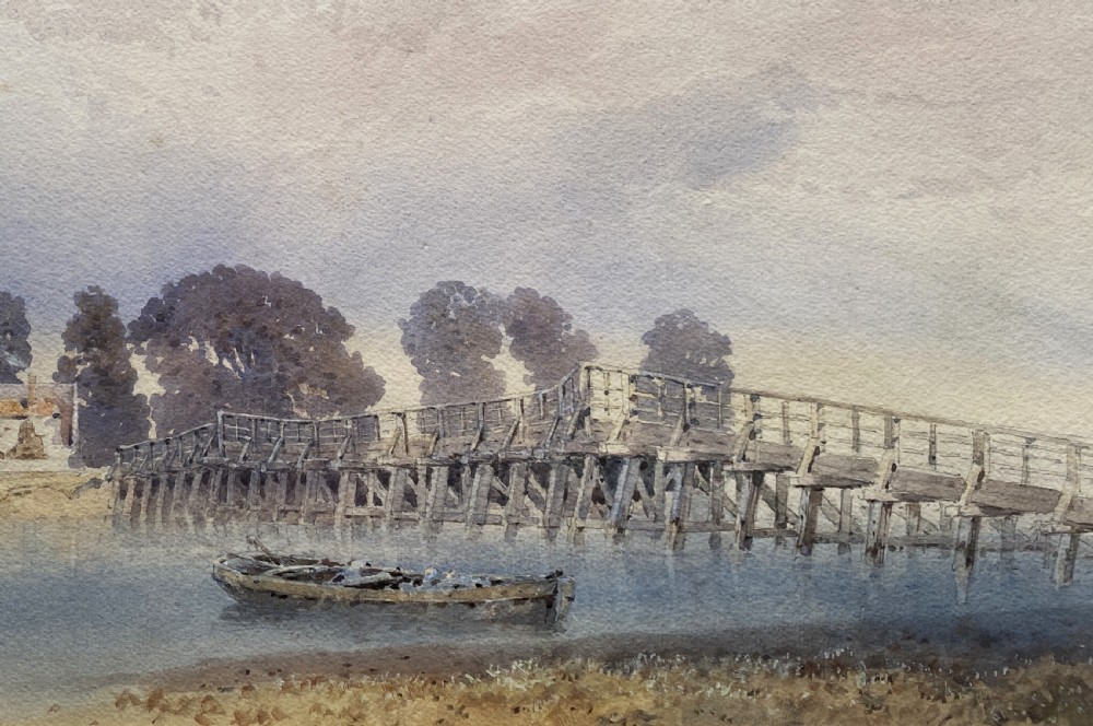A framed watercolour painting depicting a wooden toll bridge across a river with a small boat and church in the background, set in a gilded frame. View IV