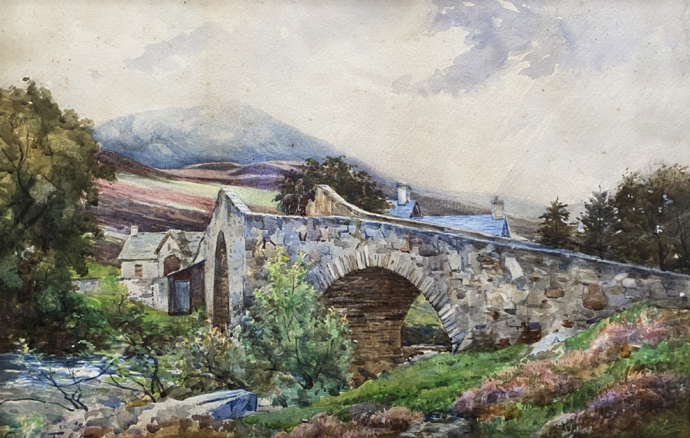 An early 20th-century watercolour painting depicting a stone arch bridge over a river surrounded by hills, set within a wide gold frame. View II