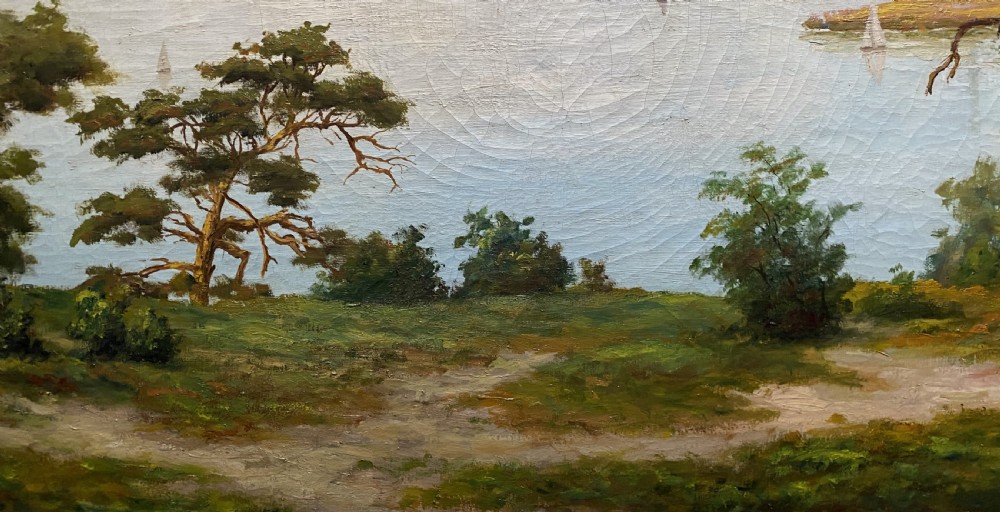 A signed 20th-century oil painting depicting a calm lake with sailboats framed by birch and pine trees in a silvered wooden frame. View VI