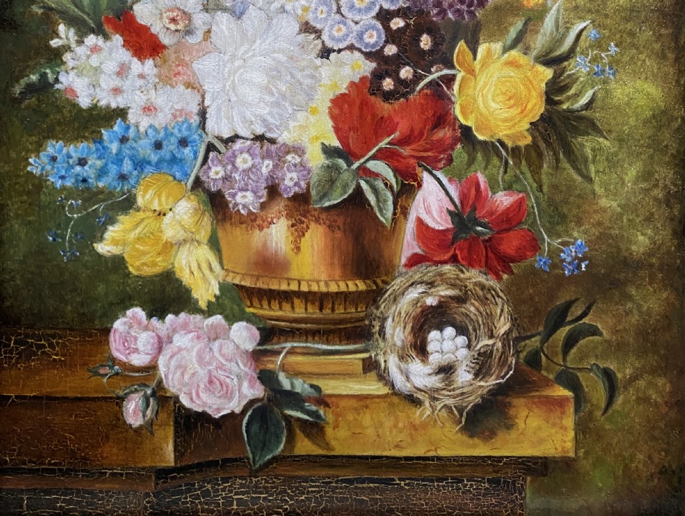 A framed oil painting featuring a floral bouquet in an urn set upon a ledge next to a bird nest. View III