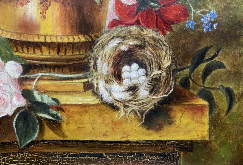 A framed oil painting featuring a floral bouquet in an urn set upon a ledge next to a bird nest. View V