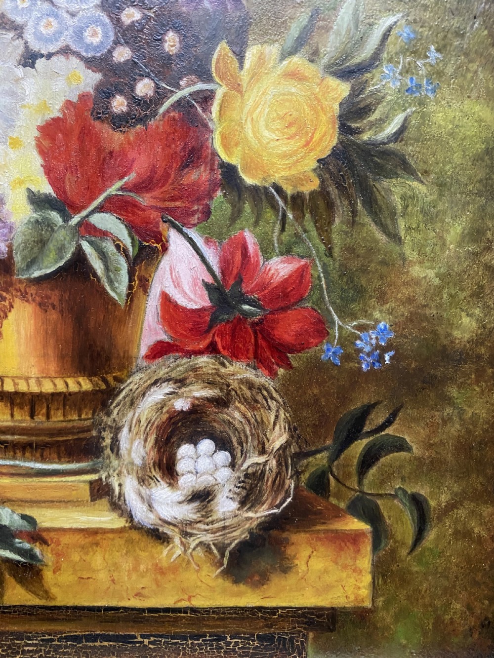 A framed oil painting featuring a floral bouquet in an urn set upon a ledge next to a bird nest. View IX