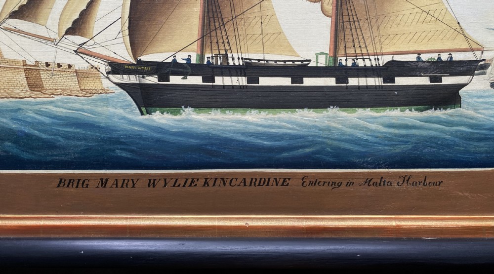 An early 19th-century marine oil painting depicting a two-masted brig ship sailing into Malta harbour, set within a black and gilt wooden frame. View V
